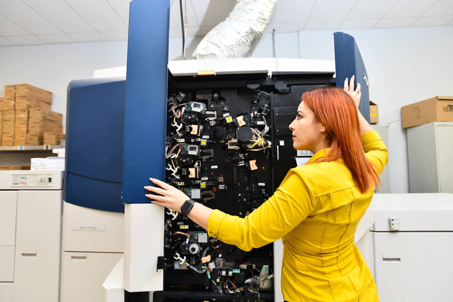 Employee examining the insides of a printer.