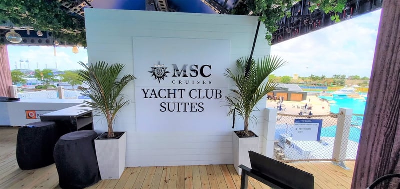MSC Cruises Yacht Club Suites sign between two potted palm trees