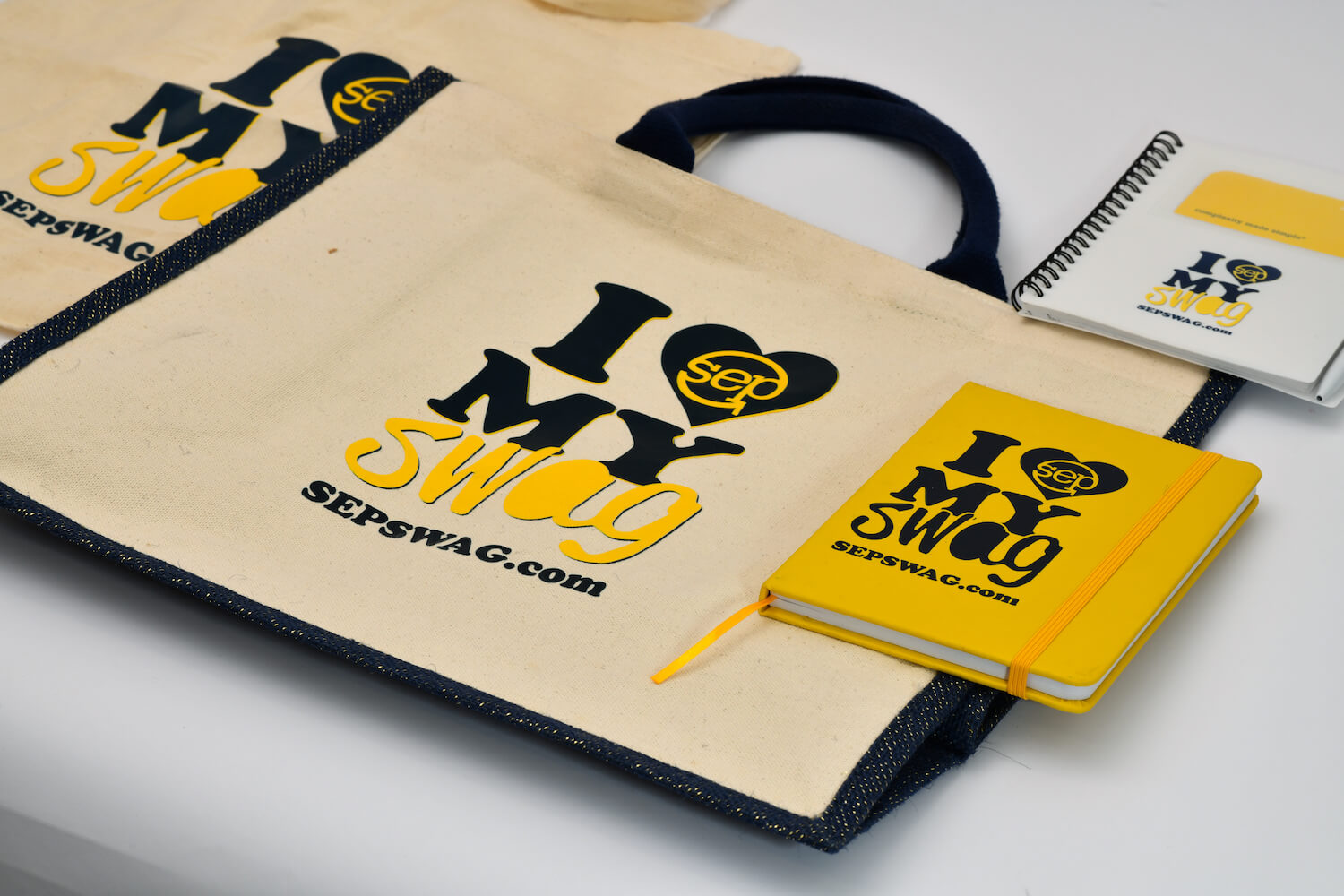 Tote bags and notebooks that say I Heart My Swag