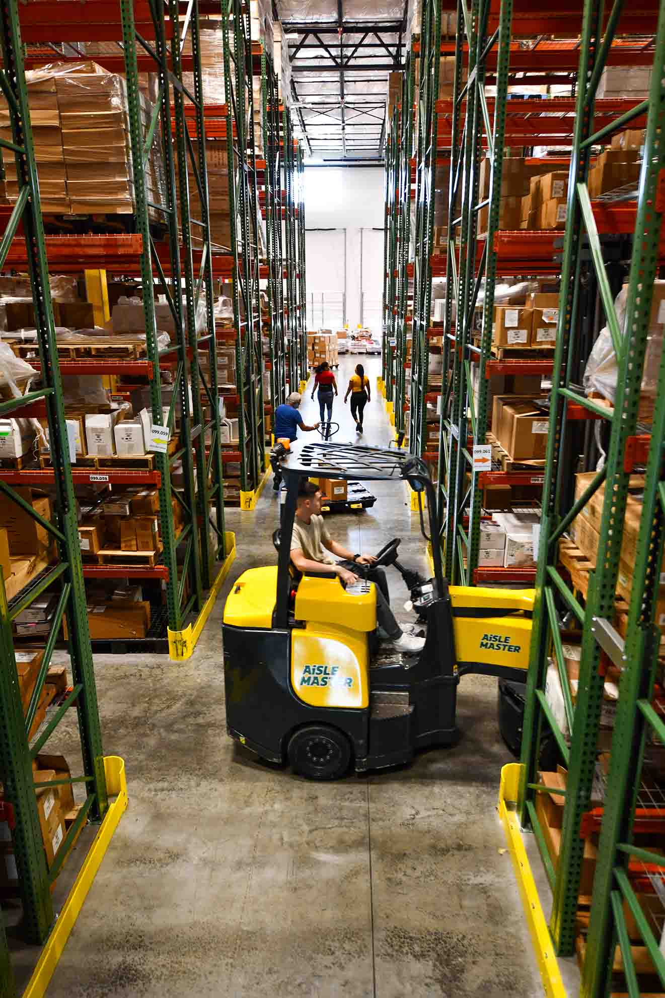 An employee maneuvering a forklift through a warehouse