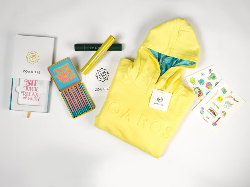Zoa Rose promotional products including a yellow hoodie and stickers